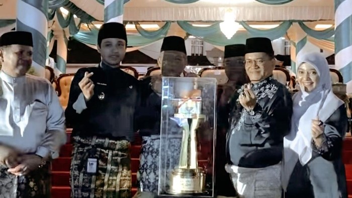 1763852691490-wako-jambi-maulana-dan-wawako-jambi-diza-hazra-aljosha-saat-menerima-piala-juara-umum-mtq-ke-54-tingkat-provinsi-1763823920039_169