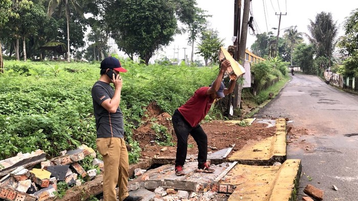 1764068747954-warga-saat-membersihkan-pagar-yang-roboh-di-bukit-siguntang-1764051573489_169