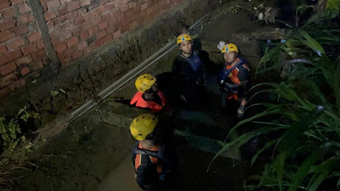 1765602330763-personel-basarnas-saat-menyisir-saluran-air-tempat-bocah-diduga-hanyut-di-jambi-1765550243674_169