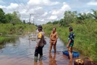 1765991143935-anggota-polsek-indralaya-utara-mengecek-kondisi-banjir-di-jalan-desa-1765946841927_169