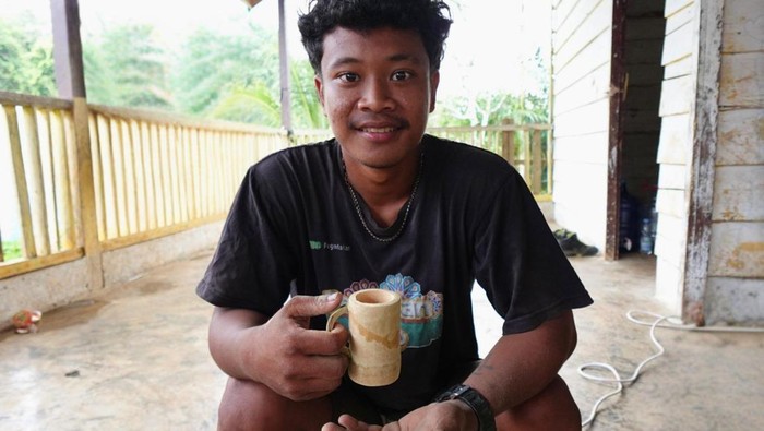 1769360760350-antoni-pemuda-suku-anak-dalam-di-sarolangun-jambi-memegang-cawan-bambu-hasil-kerajinan-tangan-komunitasnya-1769329036488_169